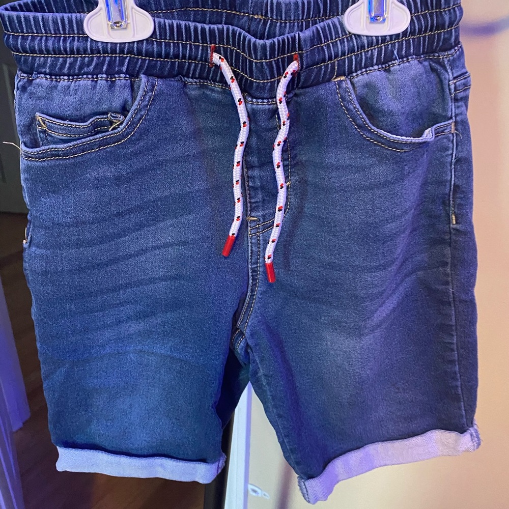 Boys pull on denim shorts.